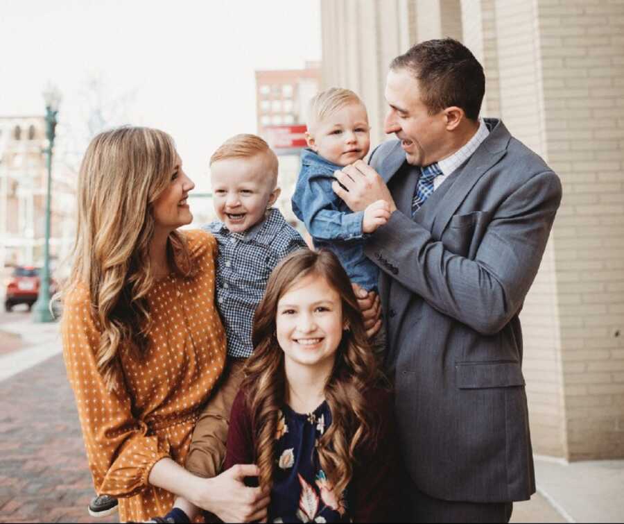 Foster family takes picture after adopting second son from foster care.