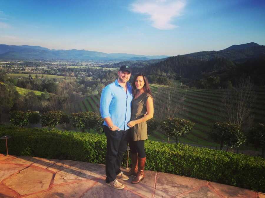 man and woman standing in front of field 