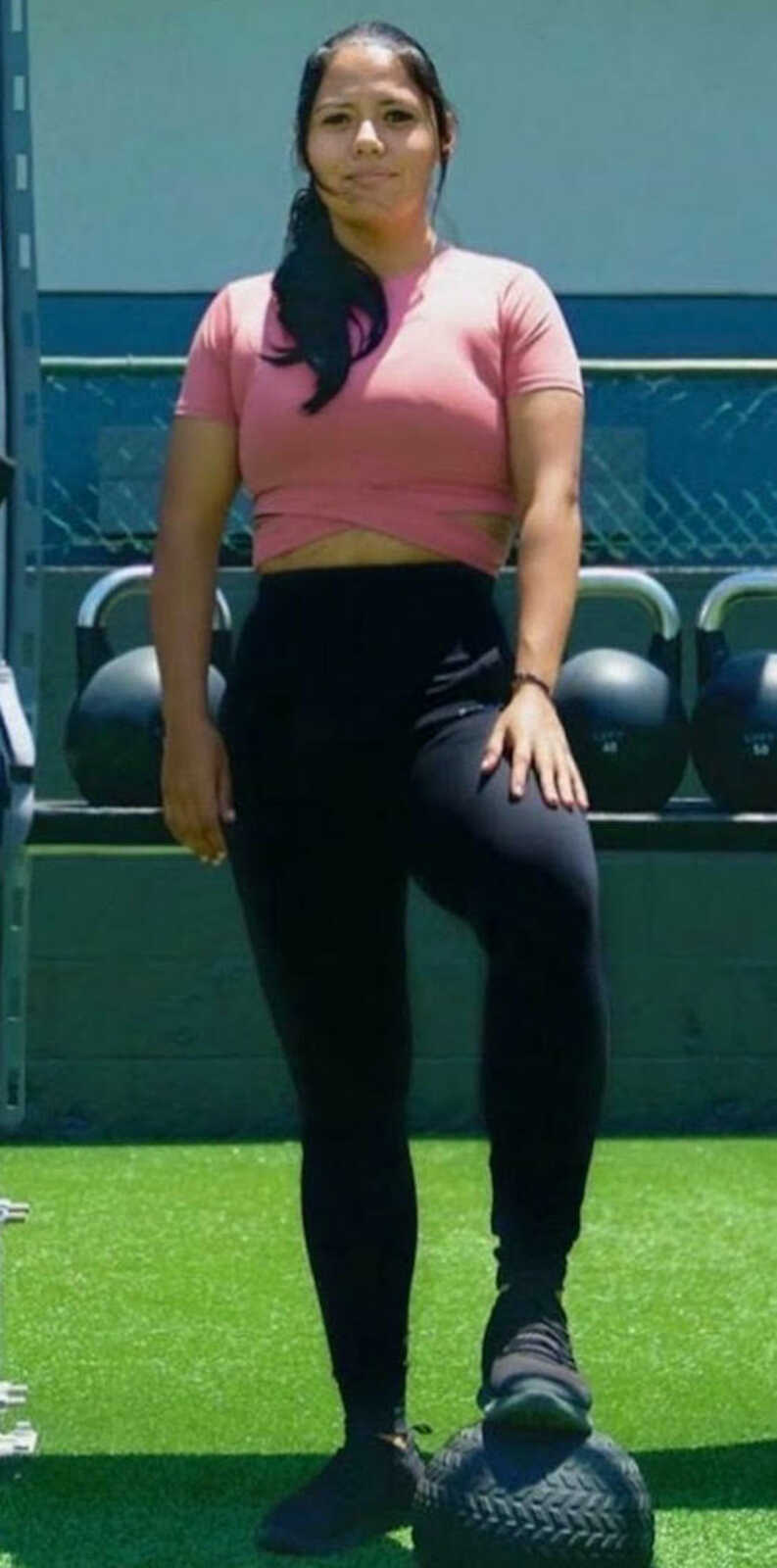 woman standing at gym smiling 