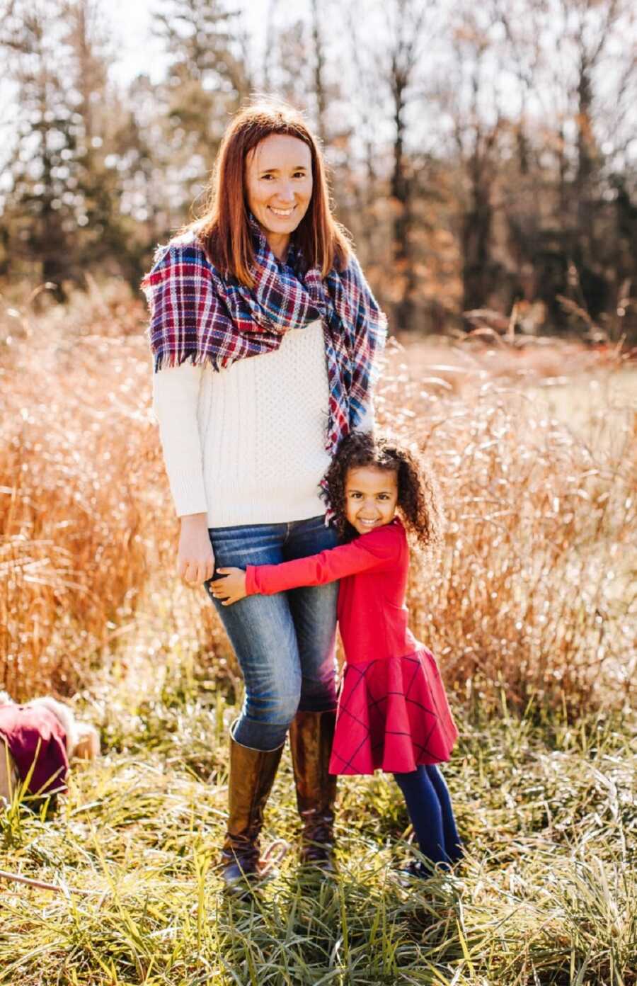 Adopted daughter wraps arms around single mom's waist.