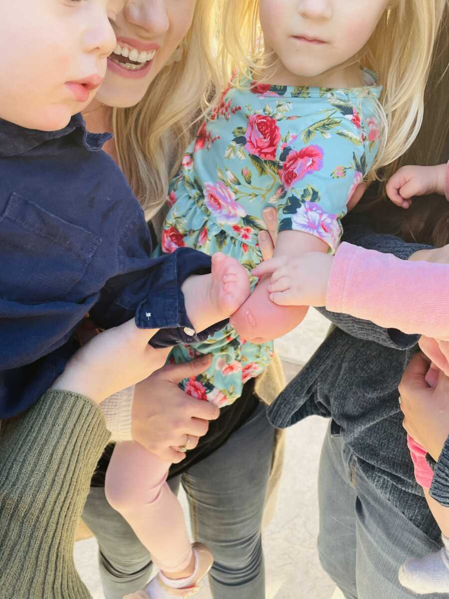 Three children with limb differences put their affected limbs together.