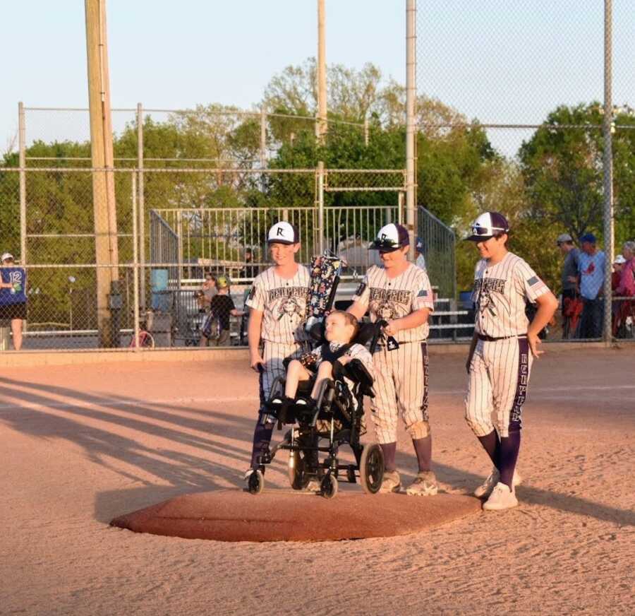 boy with disability is able to sit on the pitcher's mound
