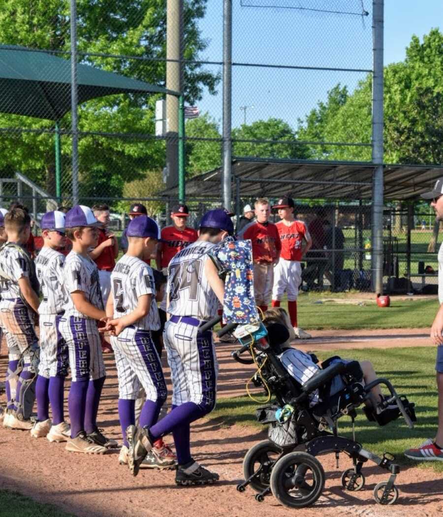 baseball team lines up with boy in wheelchair