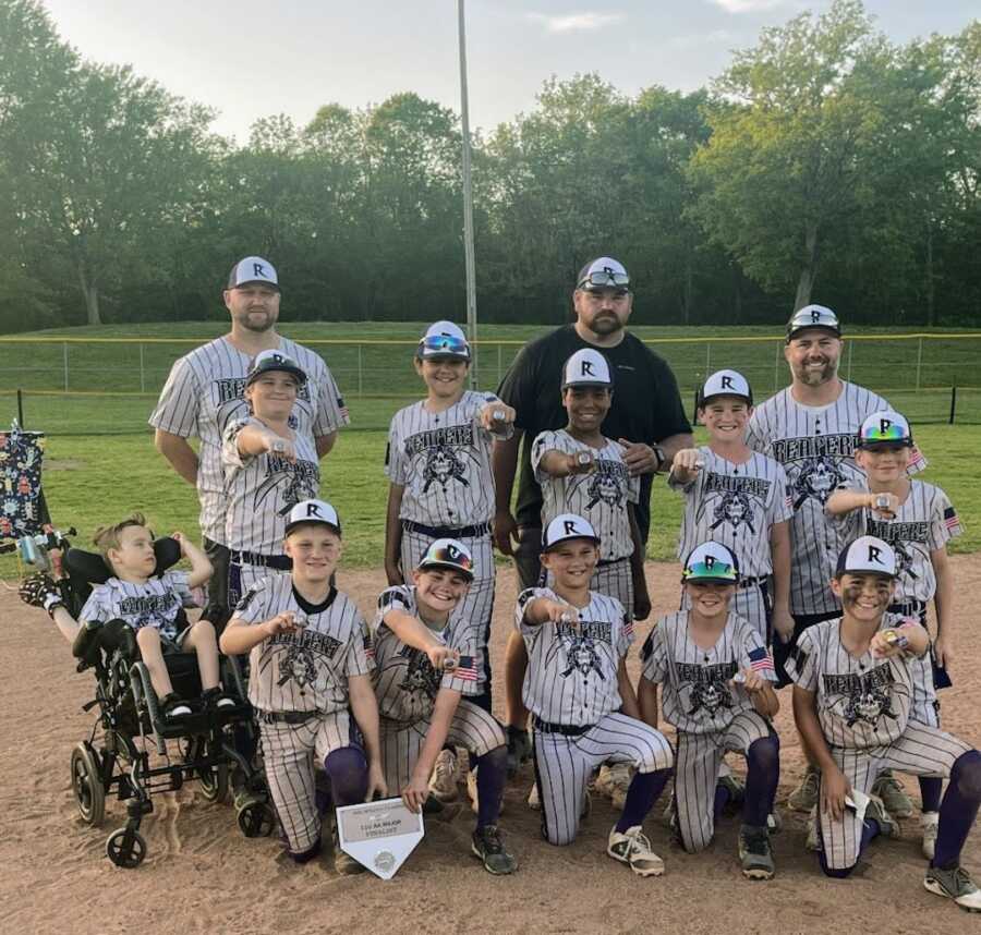 Baseball team and boy with disability pose together for a photo