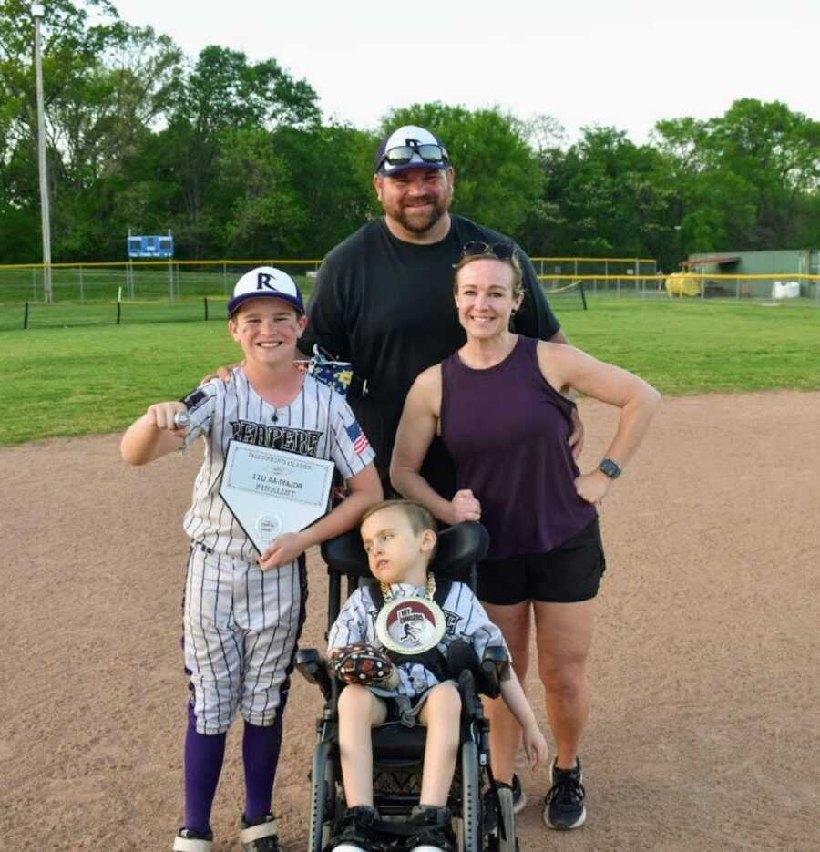 Family stands together on baseball field for a photo