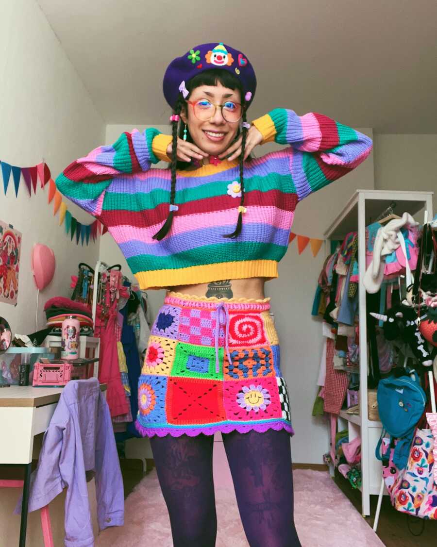 non binary person showing off their colorful outfit