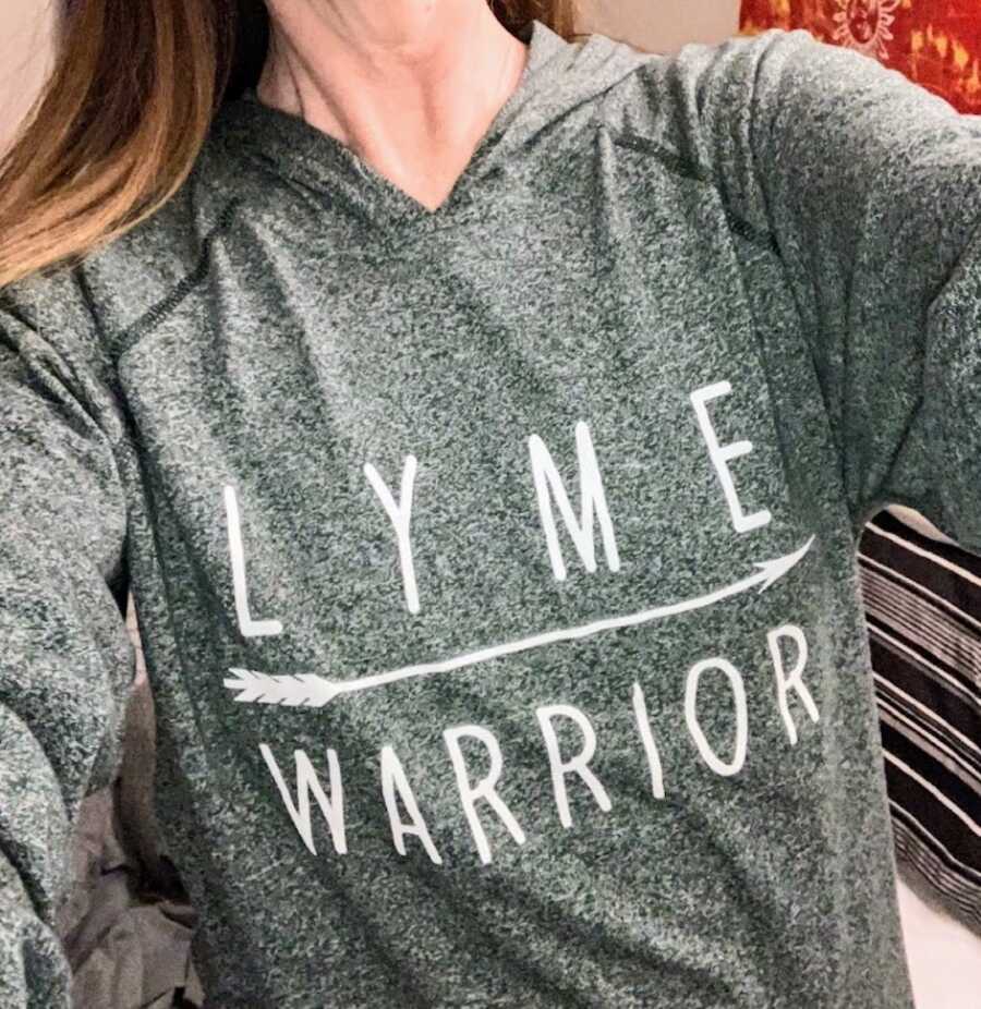 woman with lyme disease wears a lyme warrior hoodie