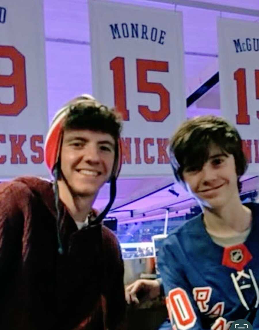 Mother's two sons pose for a photo at a hockey game