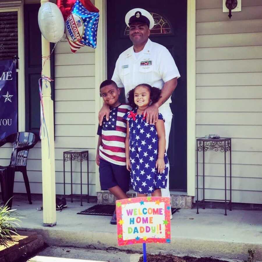 navy father poses with his two children once he comes home