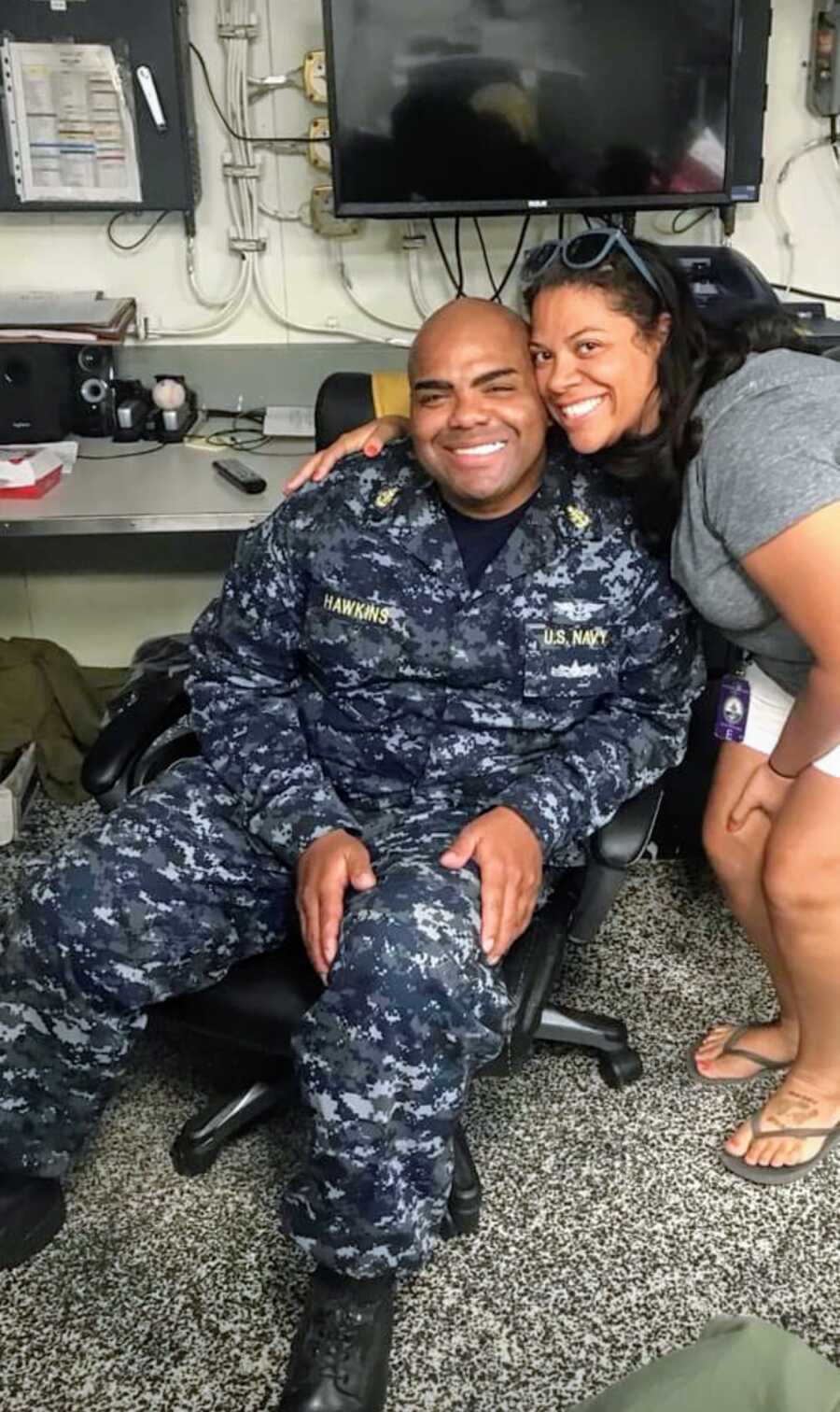 military couple poses together, both smiling