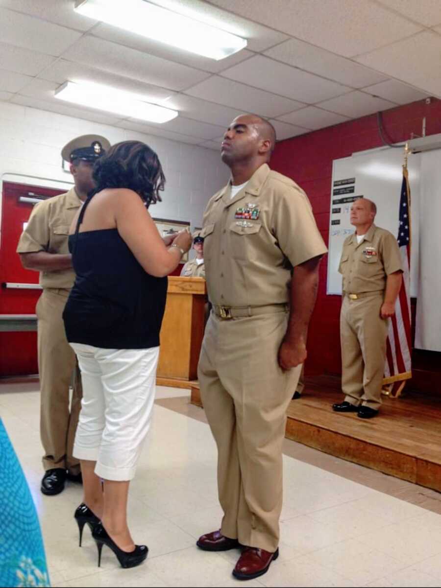 wife pins her husband at a navy ceremony