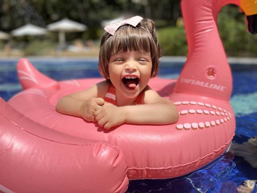 international adoptee sits in a pool float