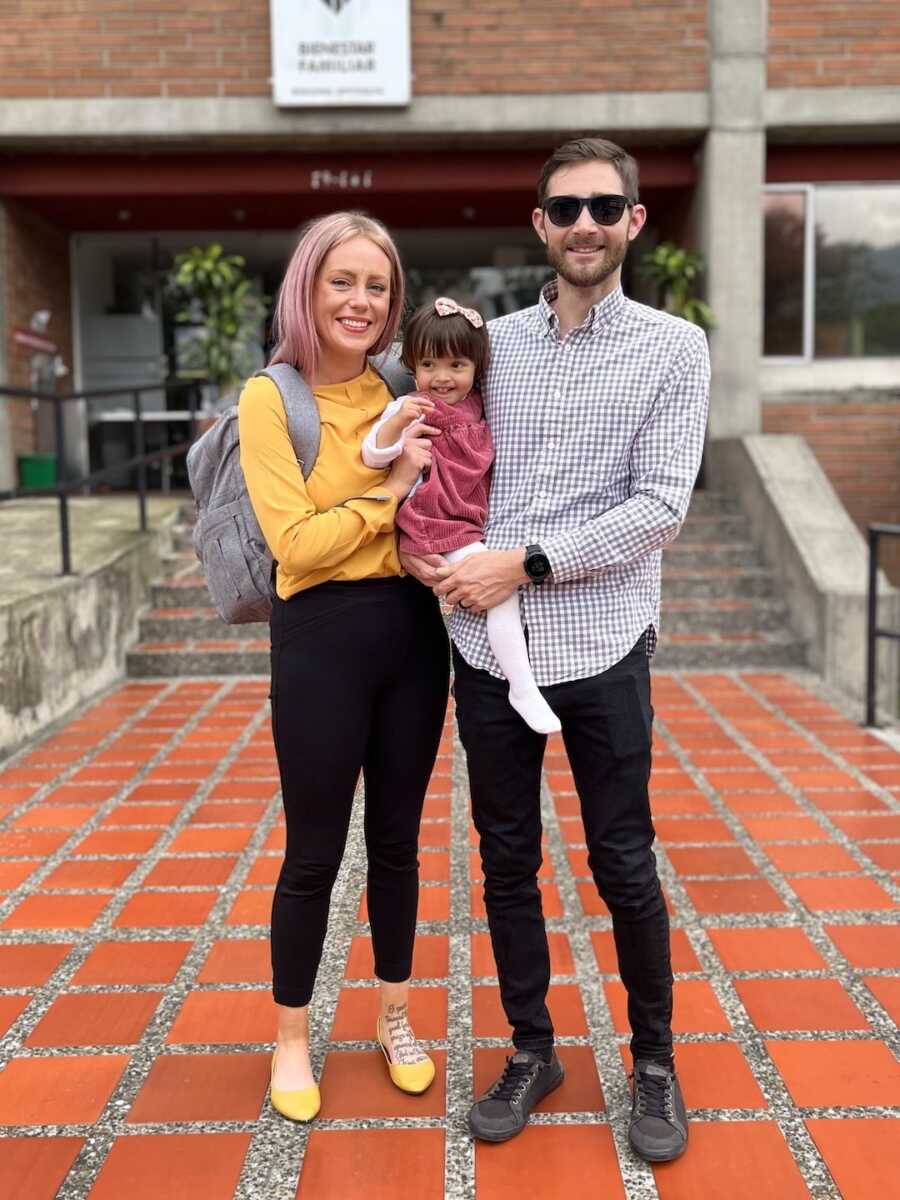 adoptive parents hold their adopted daughter after completing adoption process