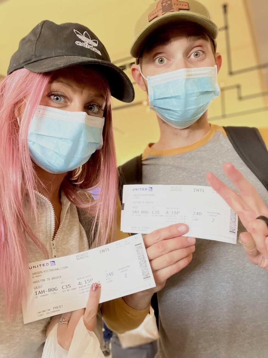 parents hold up boarding passes before traveling to adopt