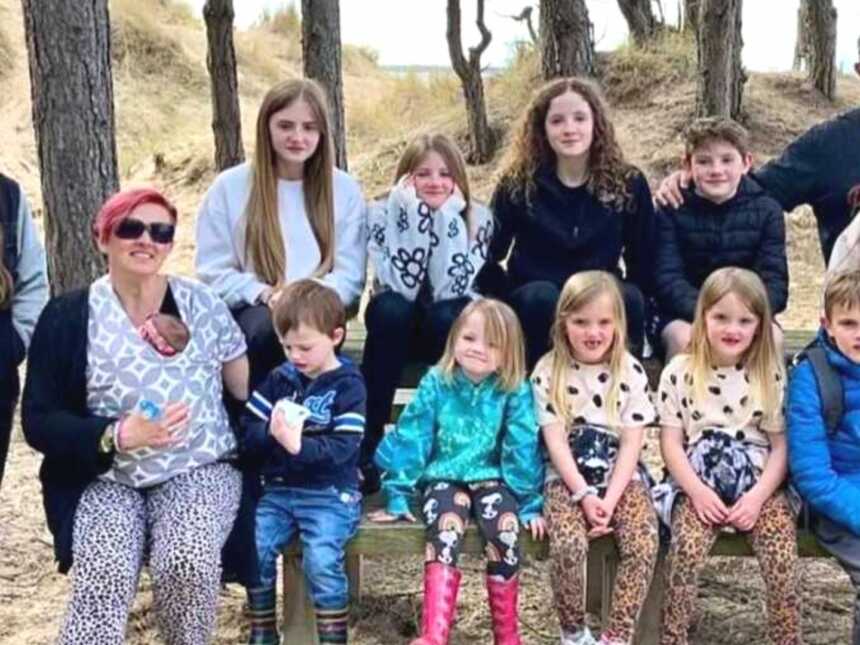 Parents with their 12 children in the woods