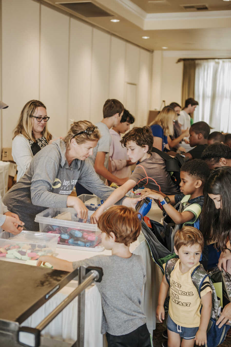 people at a charity event packing up bookbags 