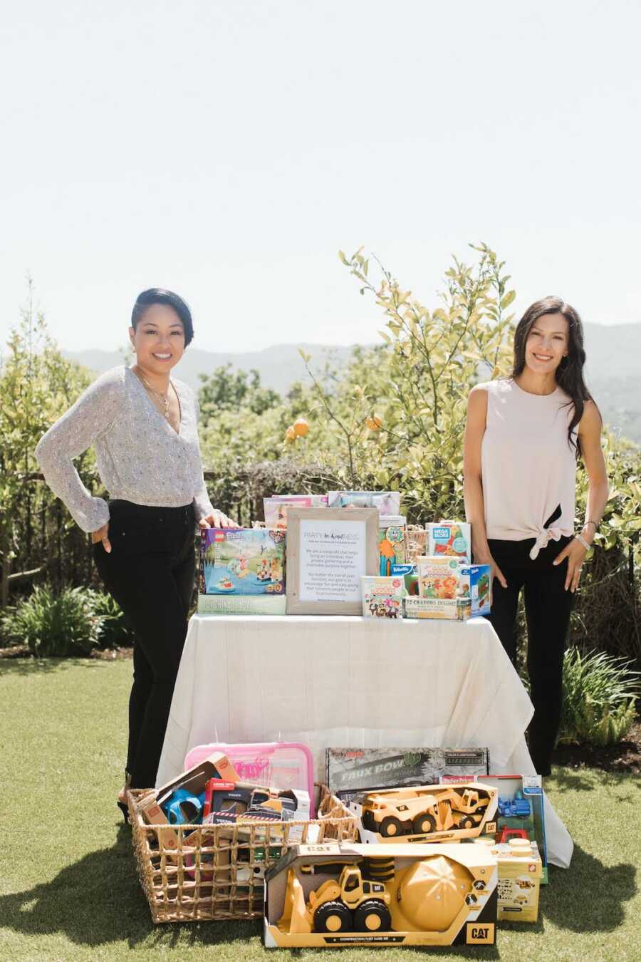 two women in front of charity items 