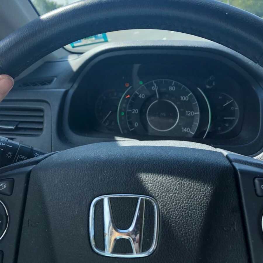 woman sitting at the wheel of her car crying