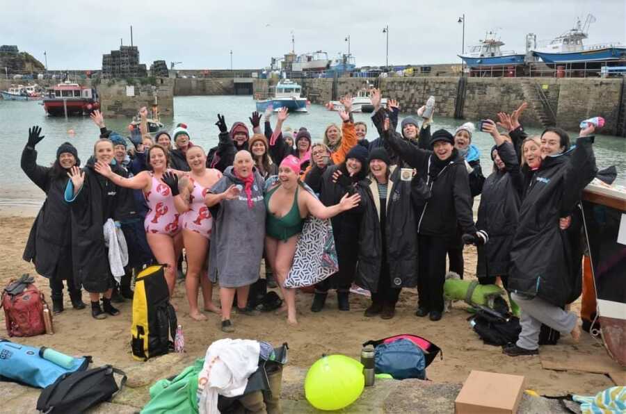 people at a lake for a cancer swim