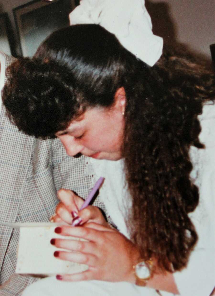 young woman writing in journal 