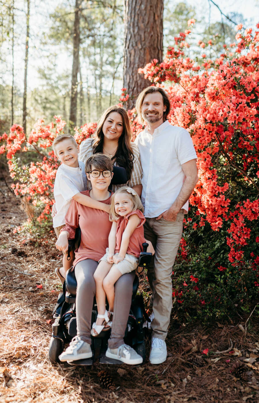 family taking photo in front of roses 