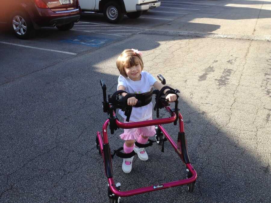 little girl walking with walker 