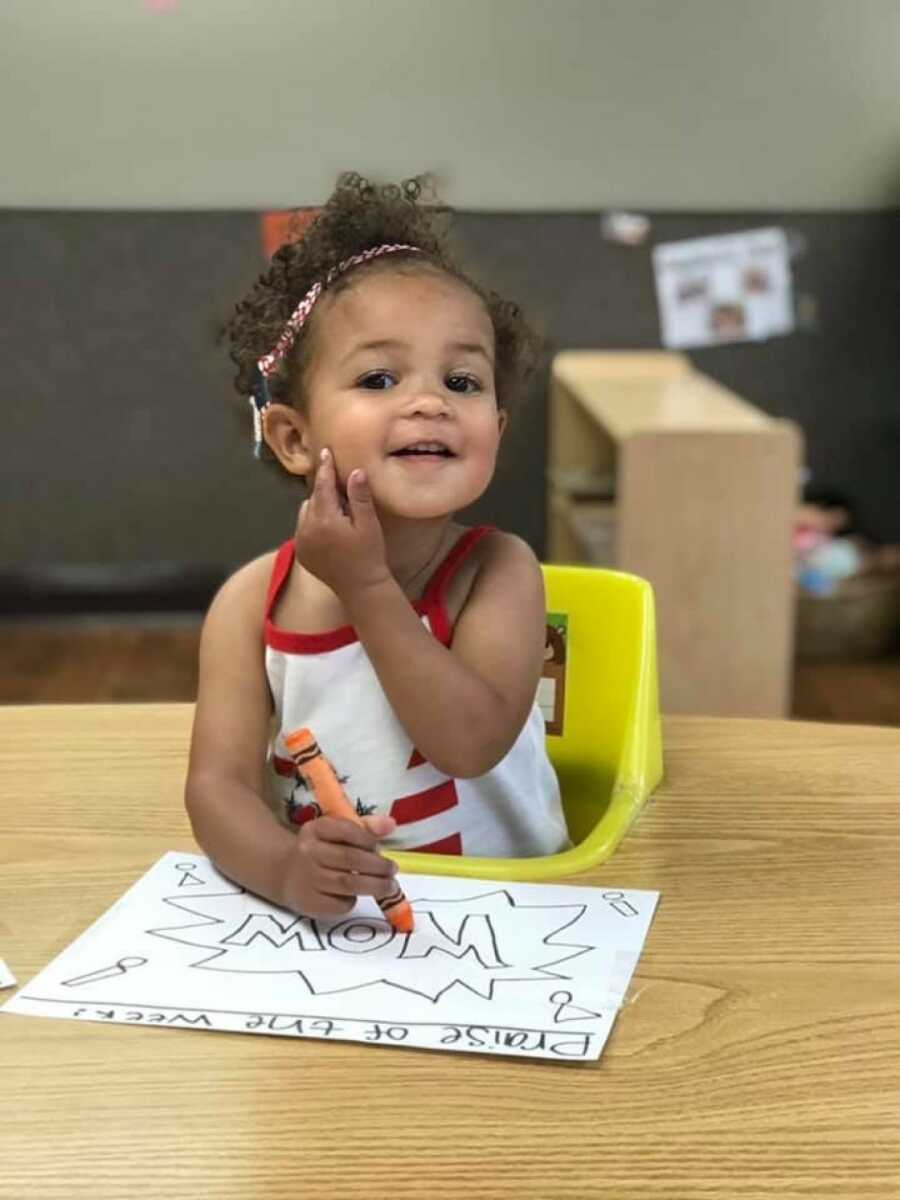 daughter coloring in a sheet of paper