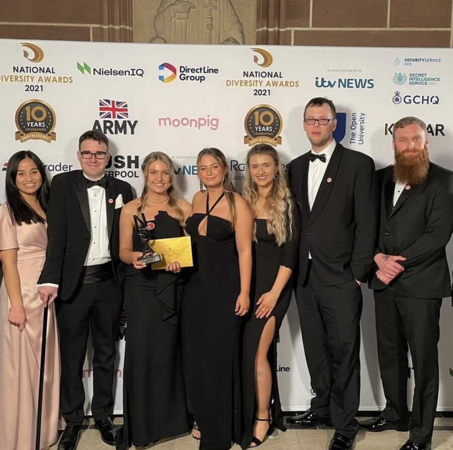 women and men standing with award