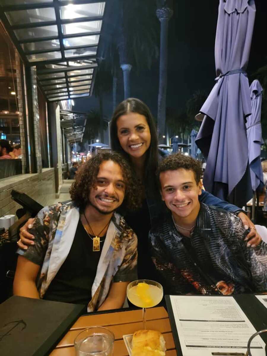 sons and mother sitting at dinner table 