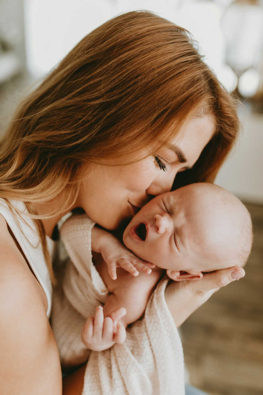 mom giving her son kisses