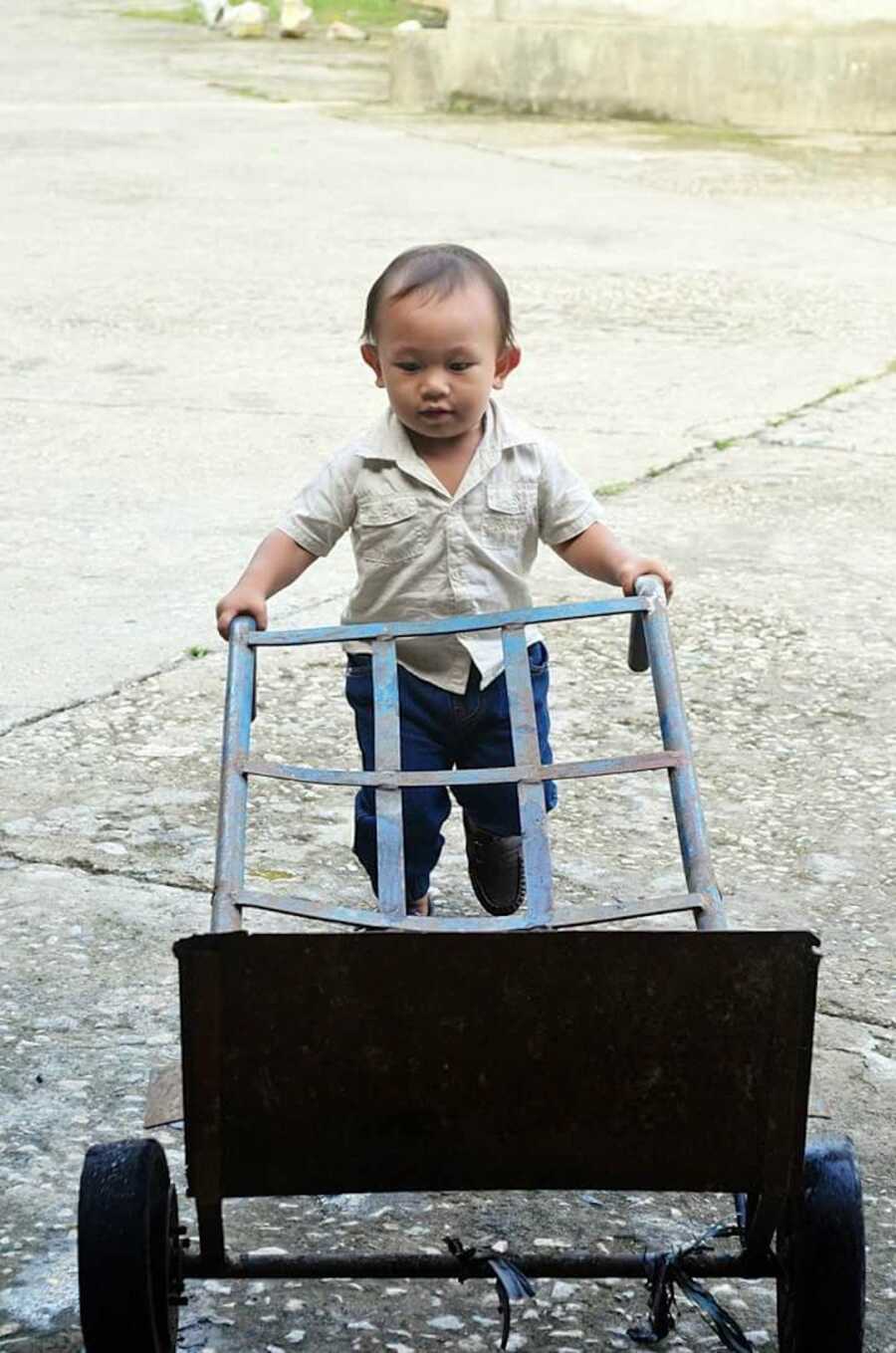 young boy pushing cart