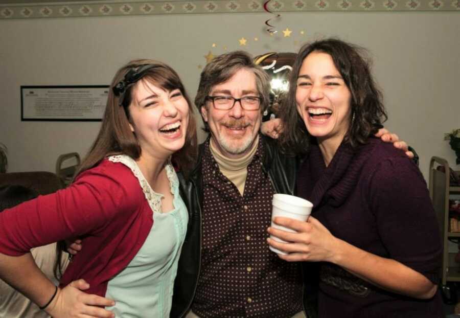 dad with his daughters laughing on a holiday