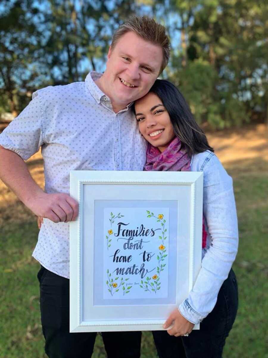 woman and her husband holding a sign 