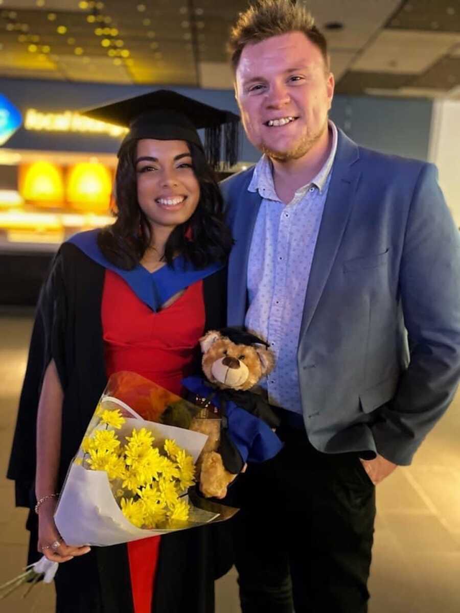 woman in graduation outfit standing with man 