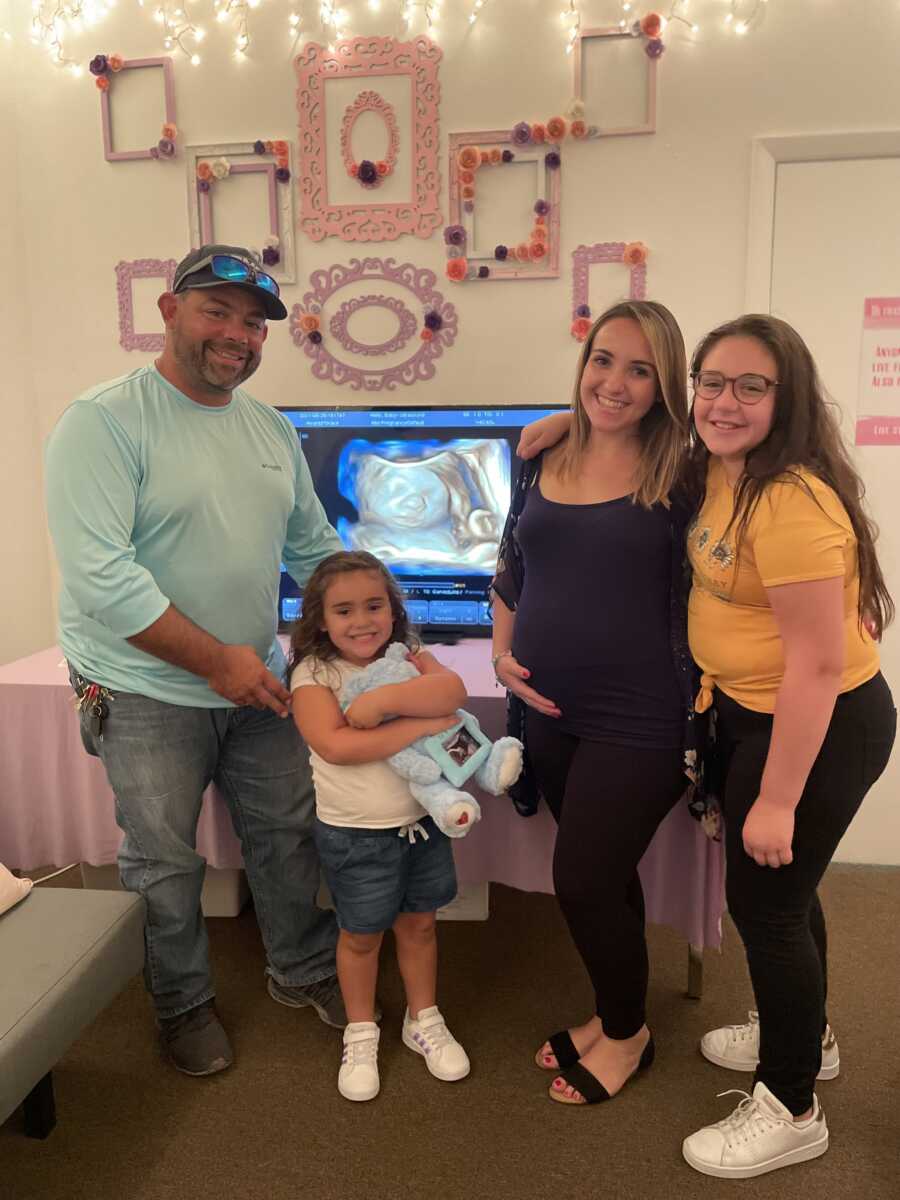 family posing around the ultrasound