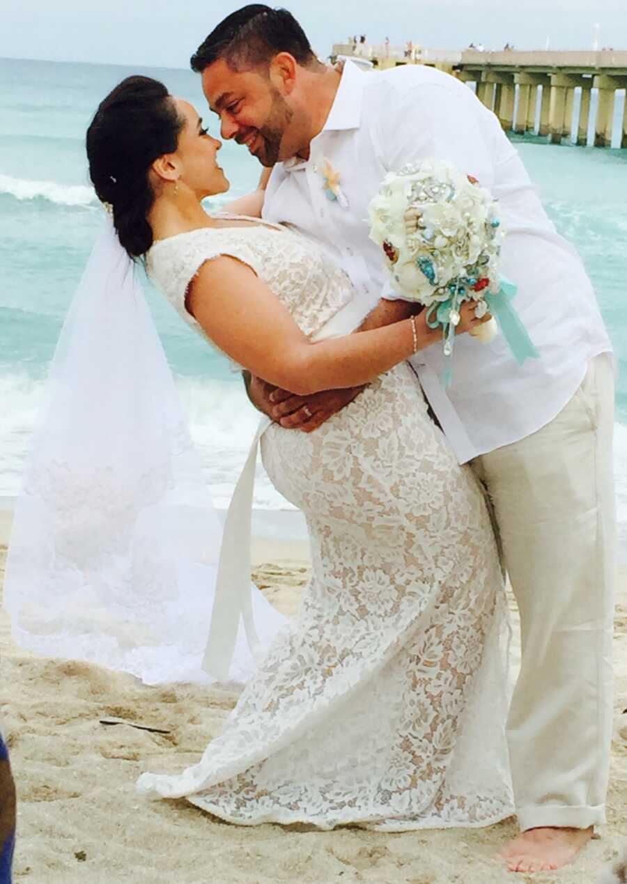 couple kissing on the beach during their wedding