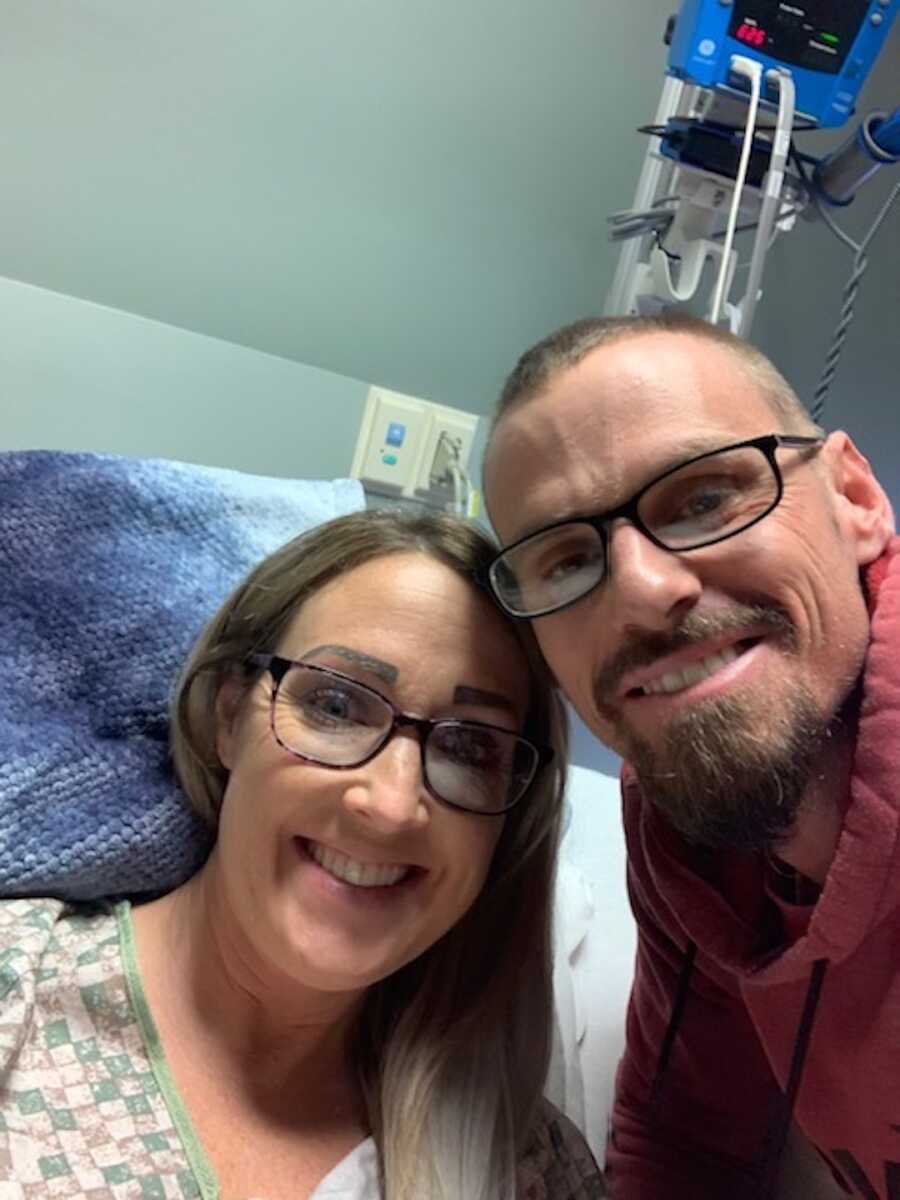 woman in hospital bed with husband next to her 