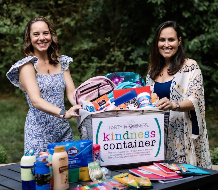 two women with a charity box in front of them