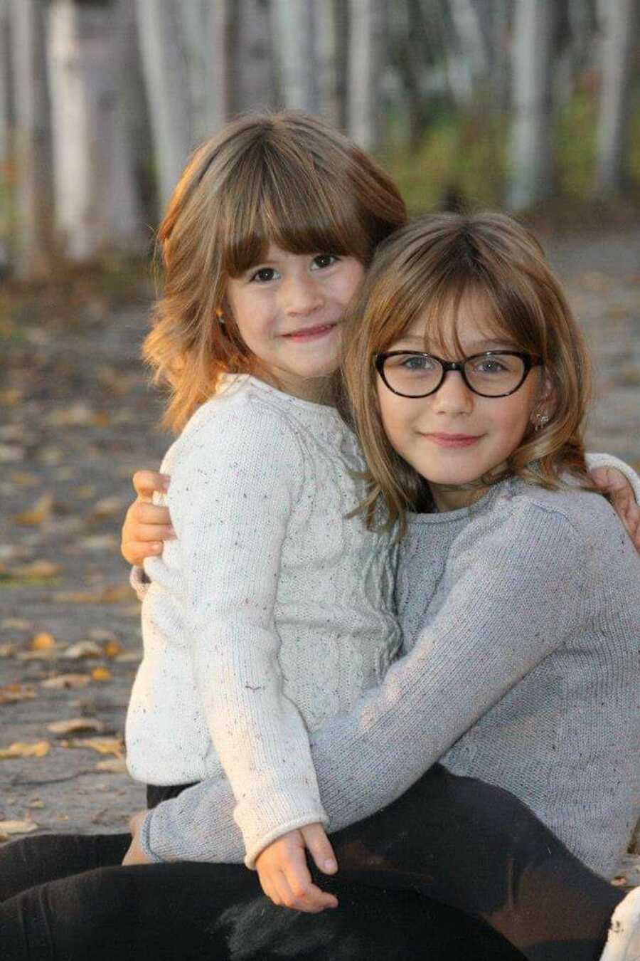 young sisters hugging and smiling 