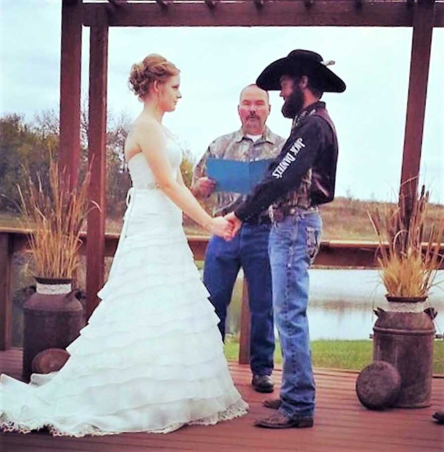 husband and wife holding hands at the altar during their wedding ceremony 