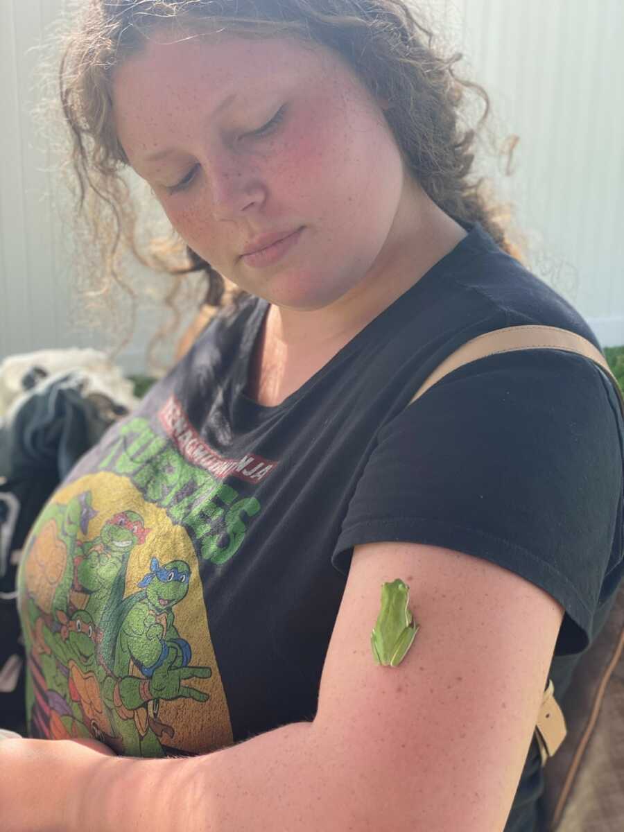 Teen foster girl with a frog on her arm.