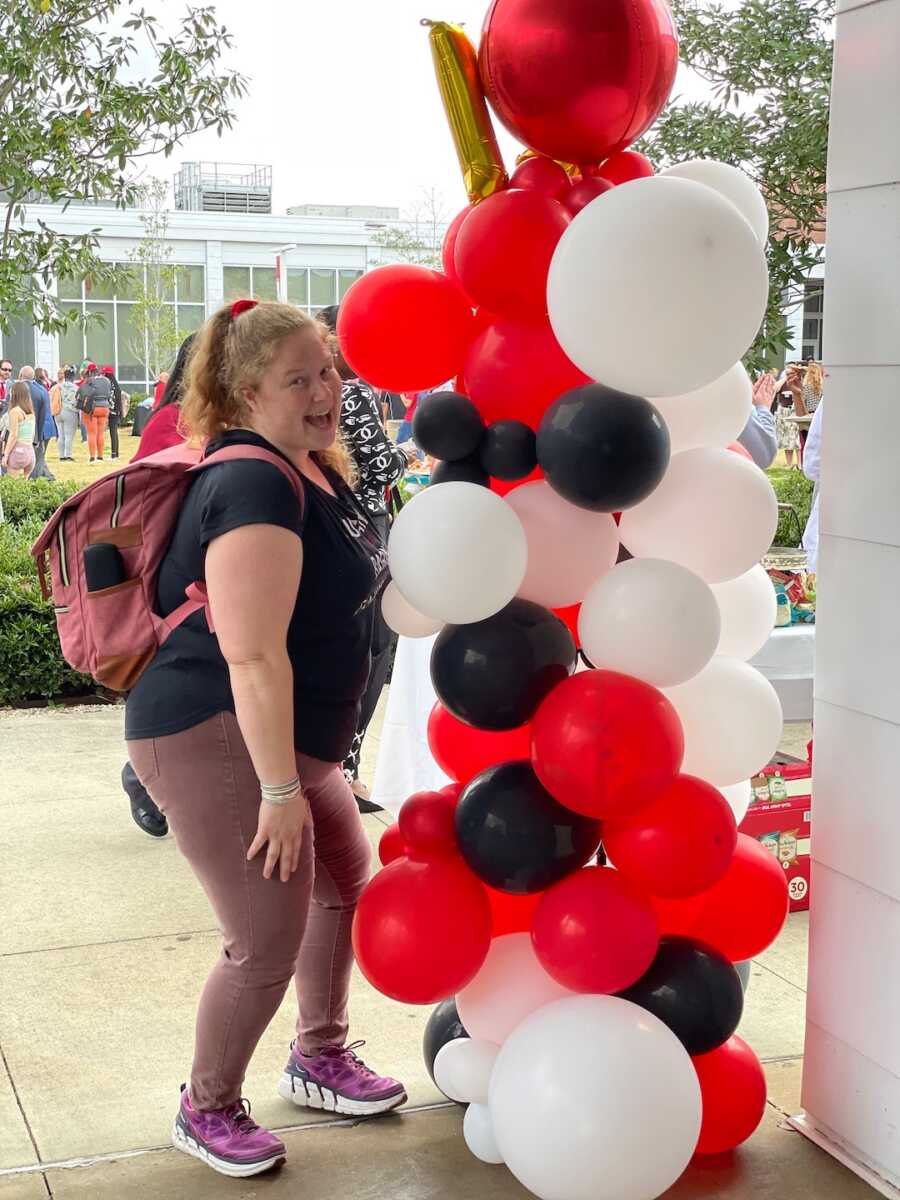 woman standing next to balloons 