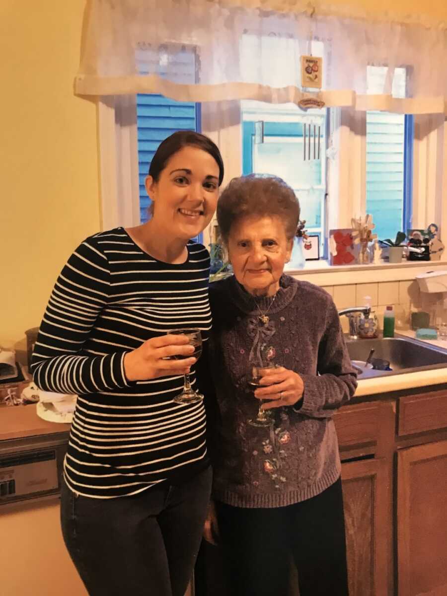 granddaughter and grandmother standing together smiling 