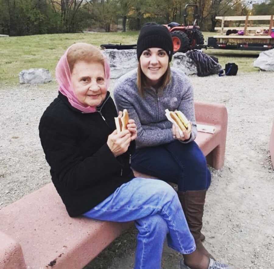 Woman takes a photo with her grandma while they enjoy hotdogs together