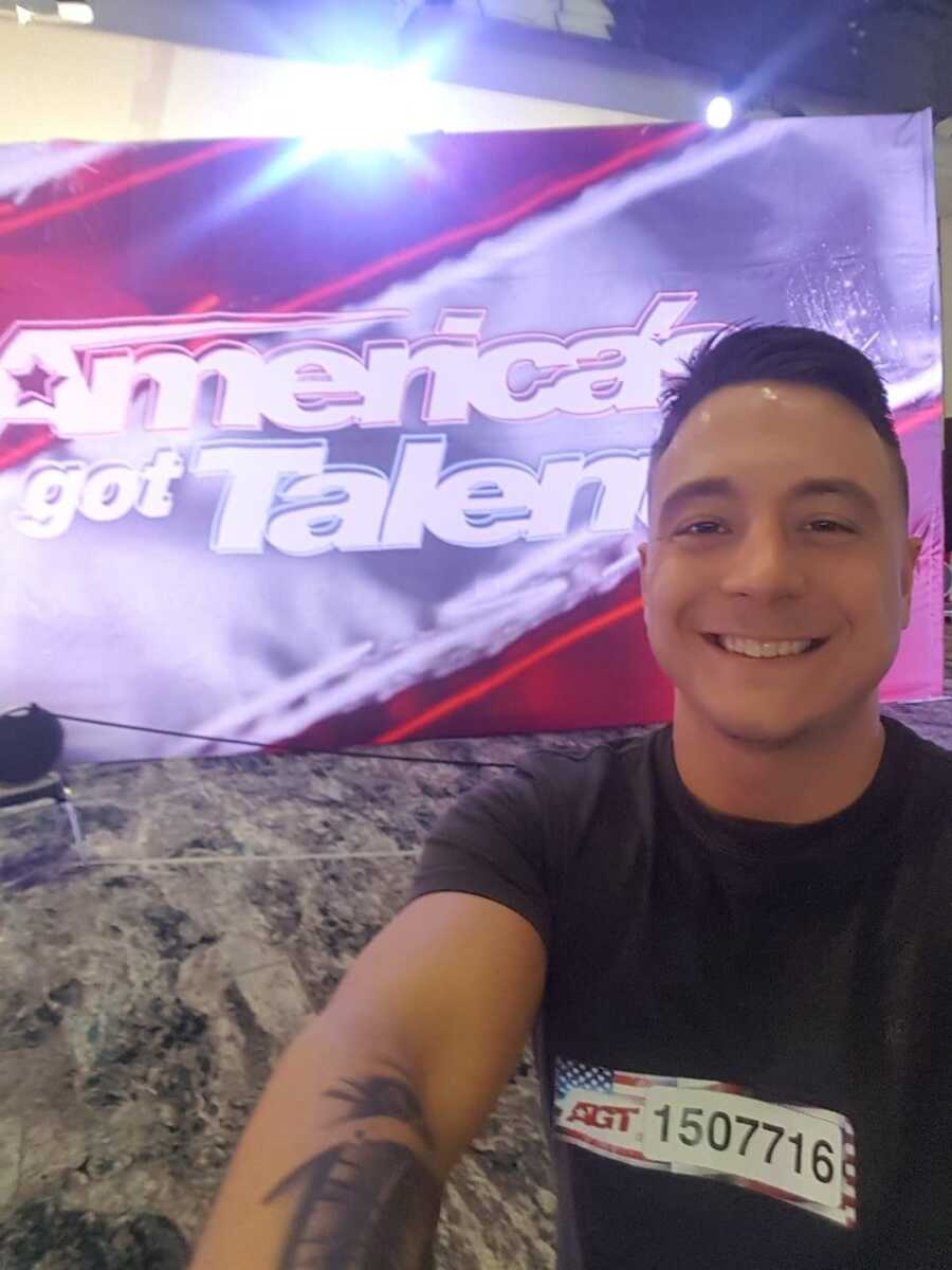 man in front of America's Got Talent sign 