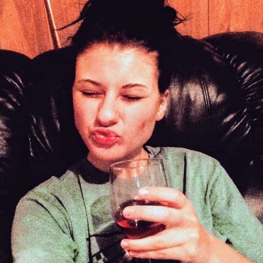 Woman battling alcoholism takes a selfie with a glass of wine