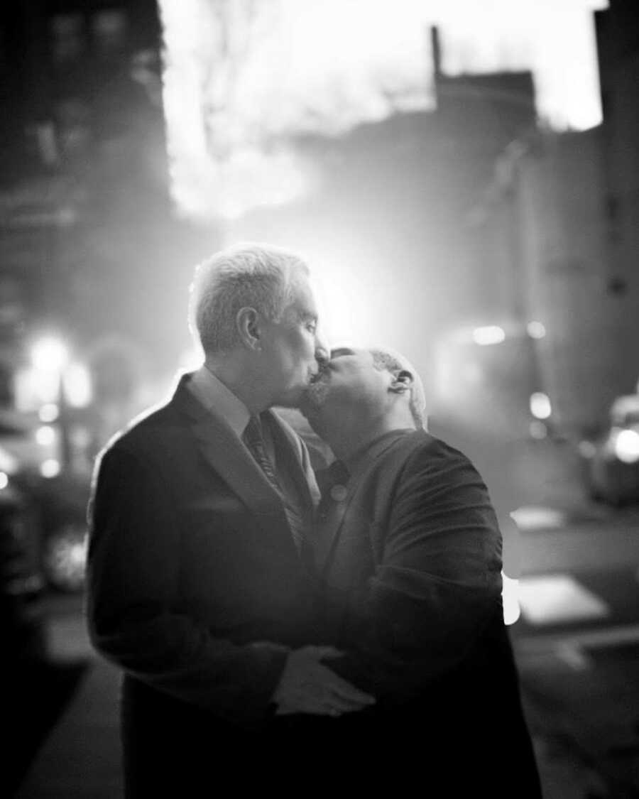 two men kissing at wedding 