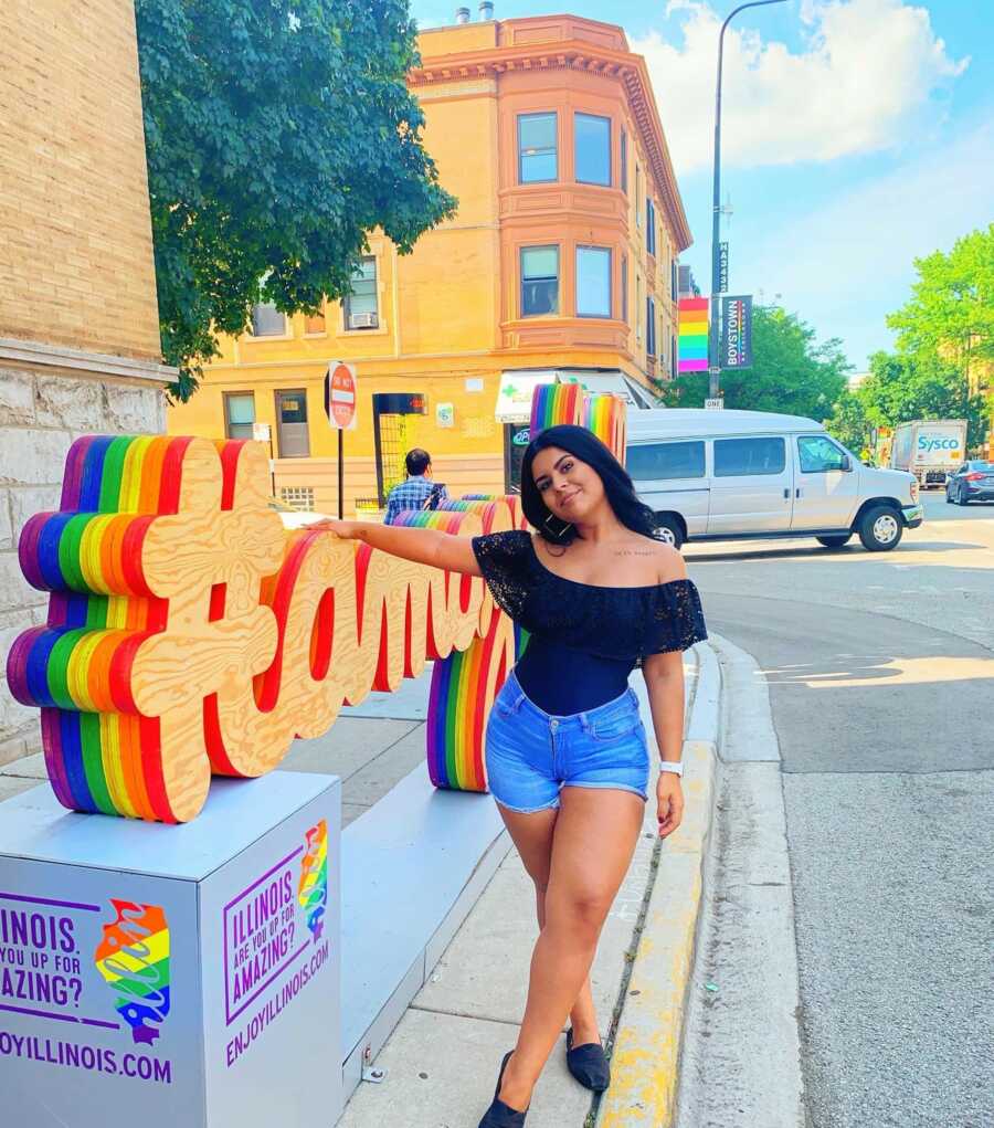 woman in front of a pride sign