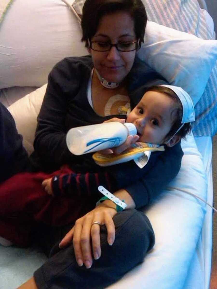 woman with cancer feeding her baby in hospital bed