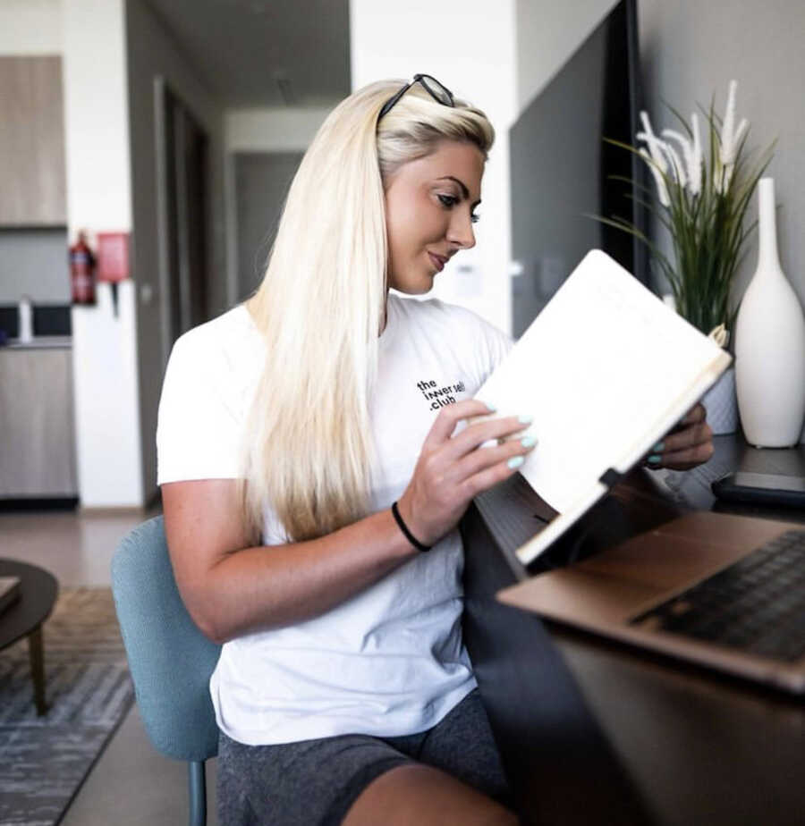 woman sitting at a desk with a notebook open 